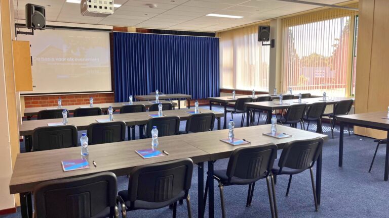 Lesruimte bij Congrescentrum de Pijler, ingericht in een schoolopstelling voor een opleiding of cursus