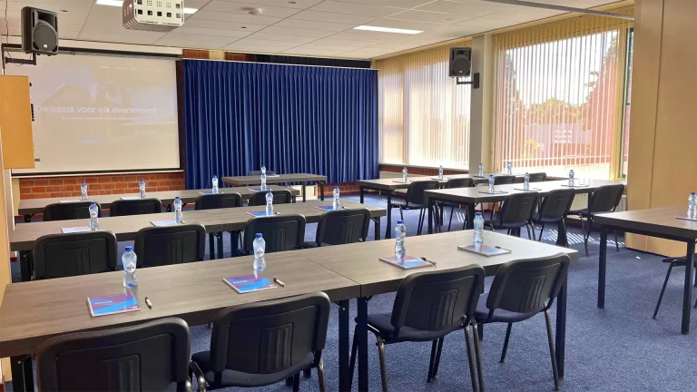Lesruimte bij Congrescentrum de Pijler, ingericht in een schoolopstelling voor een opleiding of cursus